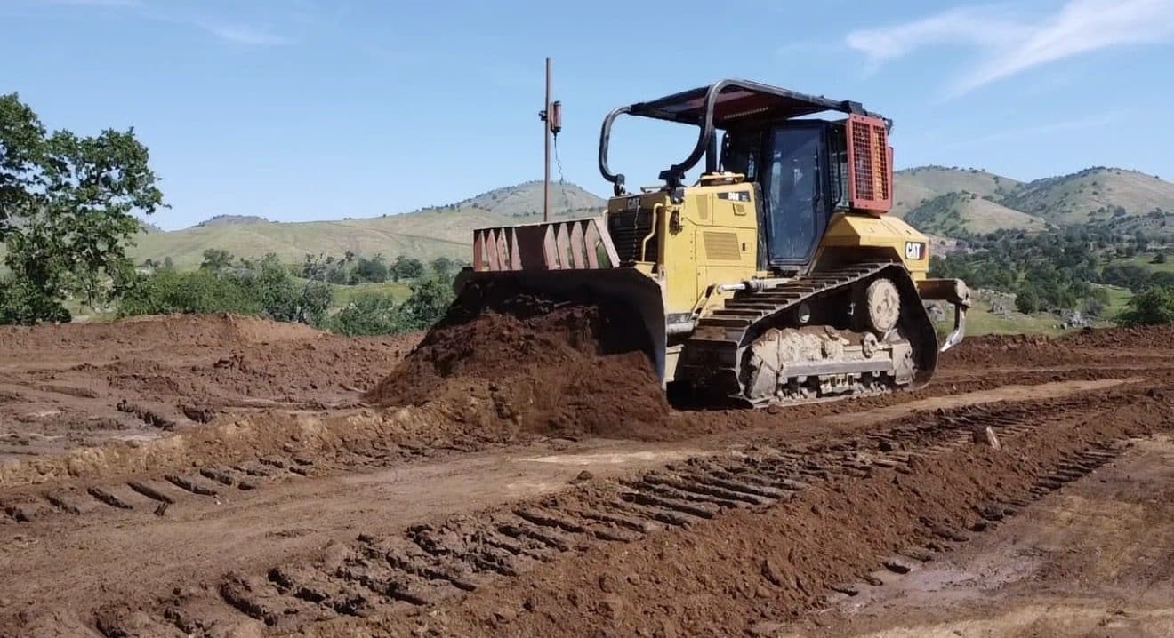Bulldozer grading a building pad on a Central Valley ranch site
